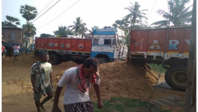 গাড়ি যাতায়াতের কারনেই বেহাল রাস্তা ! বালি বোঝাই গাড়ি আটকে রাস্তায় বালি ঢালা করাল ক্ষিপ্ত গ্রামবাসী