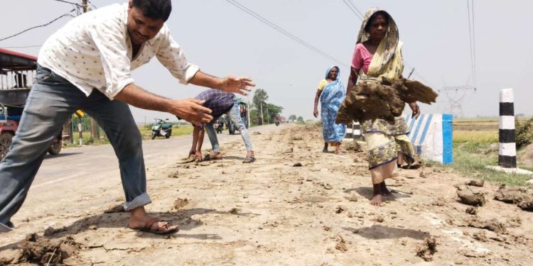 সড়ক পথে দুর্ঘটনা এড়াতে ট্রাক্টারের চাকায় উঠে আসা কাদা সরানোয় উদ্যোগী হলেন ভাতারের সমাজসেবী যুবক