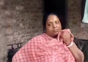 খুনের ঘটনার পুননির্মাণ করতে স্বামীকে বাড়ির সামনে দিয়ে নিয়ে যাচ্ছে পুলিশ ; উনানে বসানো পোড়া হাঁড়িতে খুদ সিদ্ধ করতে করতে তা দেখে অঝোরে কেঁদে চলেছেন স্ত্রী 