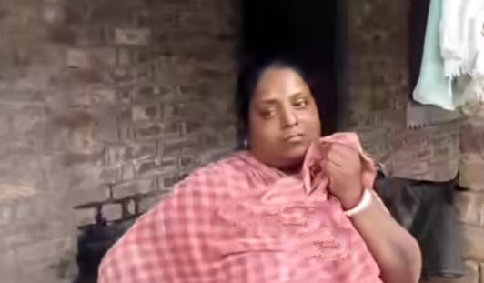 খুনের ঘটনার পুননির্মাণ করতে স্বামীকে বাড়ির সামনে দিয়ে নিয়ে যাচ্ছে পুলিশ ; উনানে বসানো পোড়া হাঁড়িতে খুদ সিদ্ধ করতে করতে তা দেখে অঝোরে কেঁদে চলেছেন স্ত্রী 